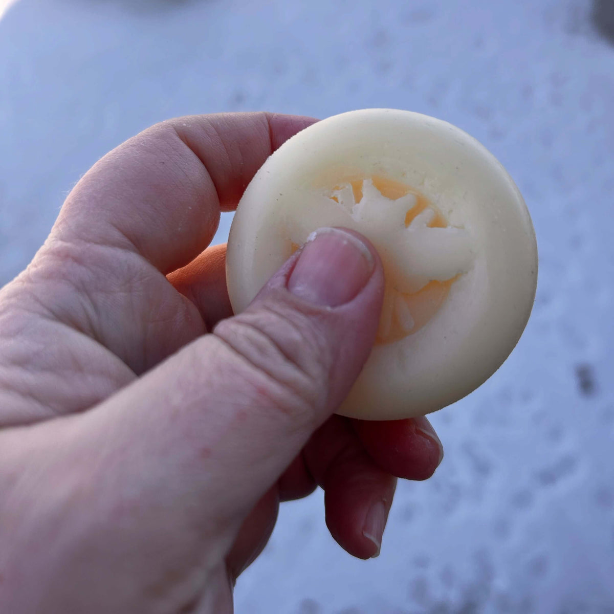 Hand holding a Solid Lotion Bar, showcasing its smooth texture and natural ingredients for soothing dry skin.
