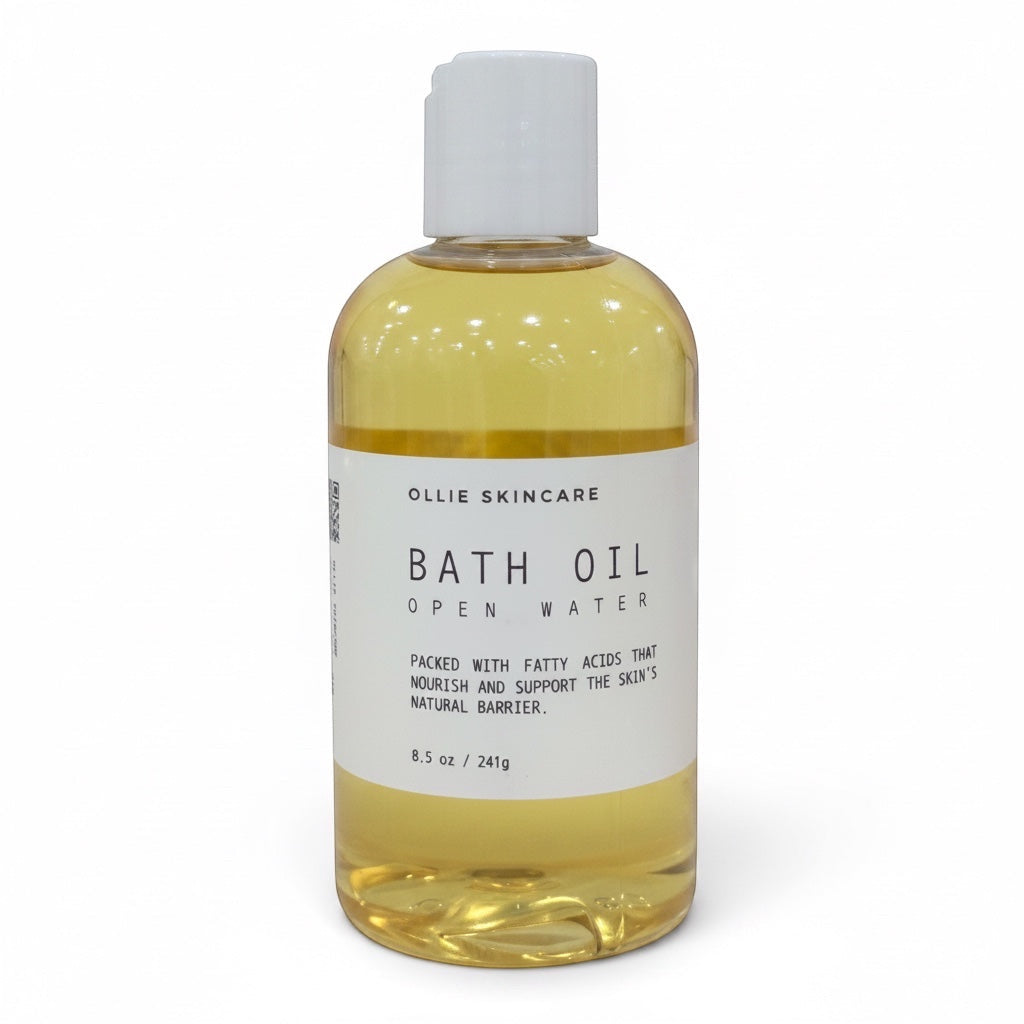 OLLIE SKINCARE Open Water bath oil in a clear 8.5 oz bottle with a white cap for deep skin hydration.