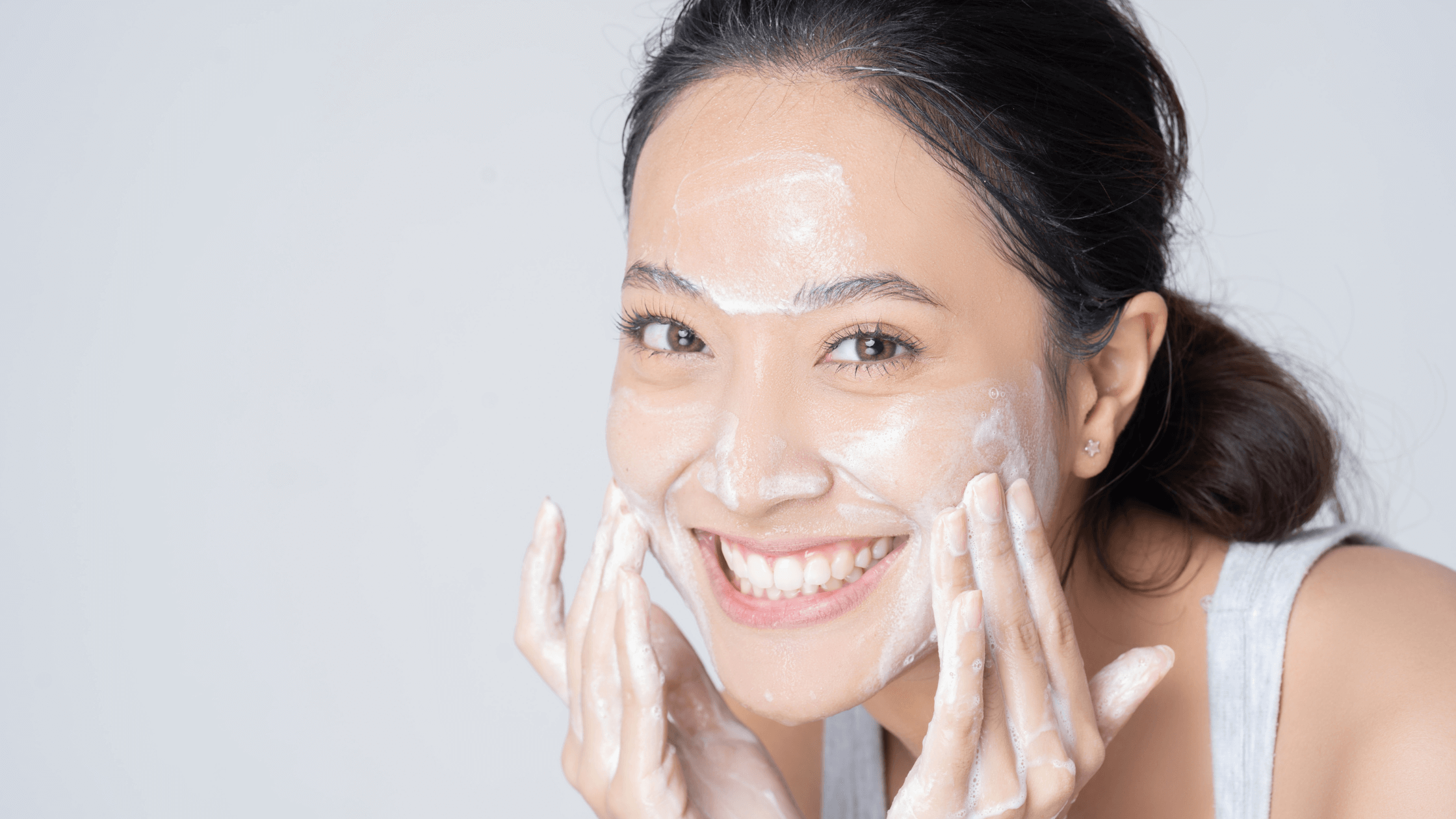 10 Steps To a Cleaner, Softer Face with Goat Milk Soap for Acne - Woman applying soap to her face, smiling.