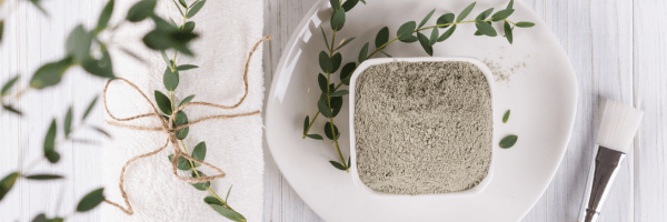 The Ultimate Guide to Cleansing Grains for Face - natural cleansing grains in a bowl with greenery.