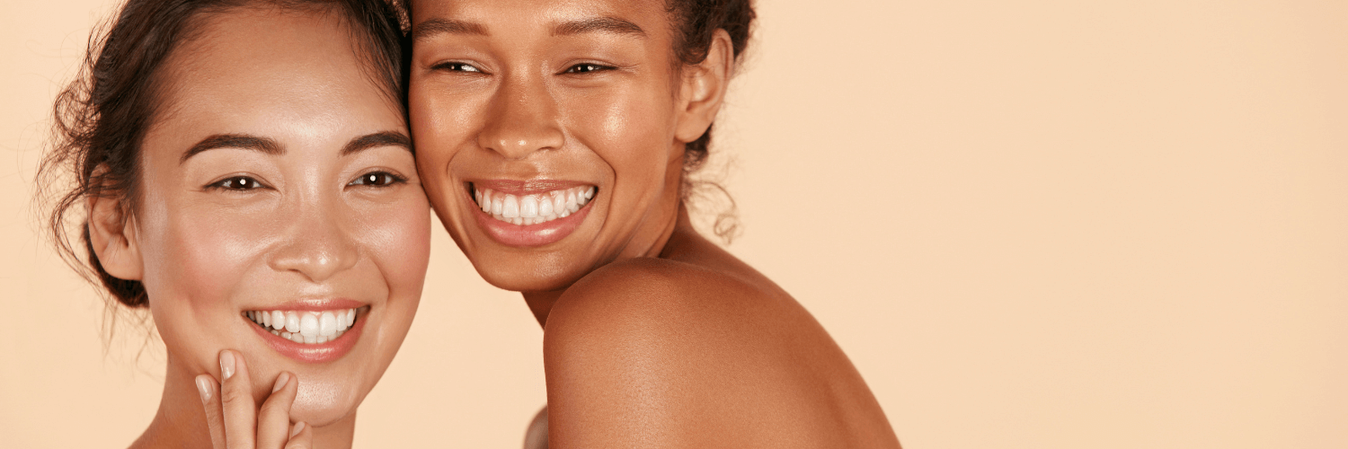 Two smiling women showcasing glowing skin, illustrating tips from the article on how to create the perfect skin care routine.