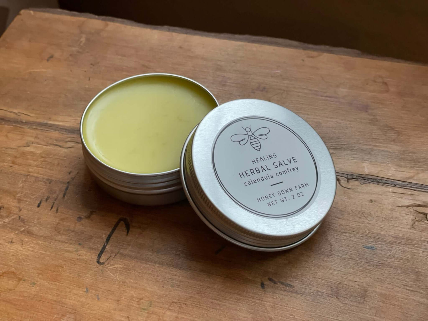 Healing herbal salve in a tin on a wooden surface, ideal for skincare routines and moisturizing, pick the best moisturizer.