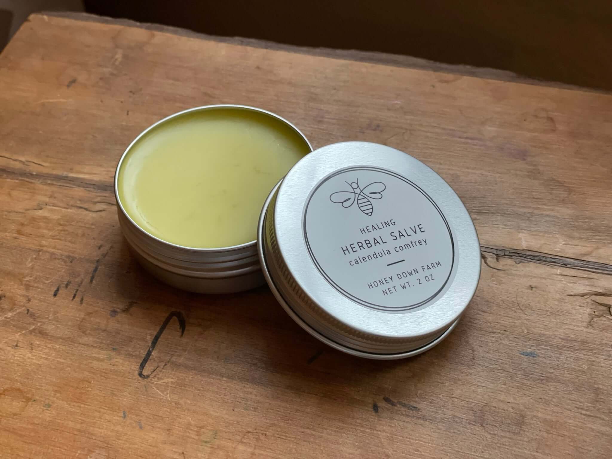 Healing herbal salve in a tin on a wooden surface, ideal for skincare routines and moisturizing, pick the best moisturizer.