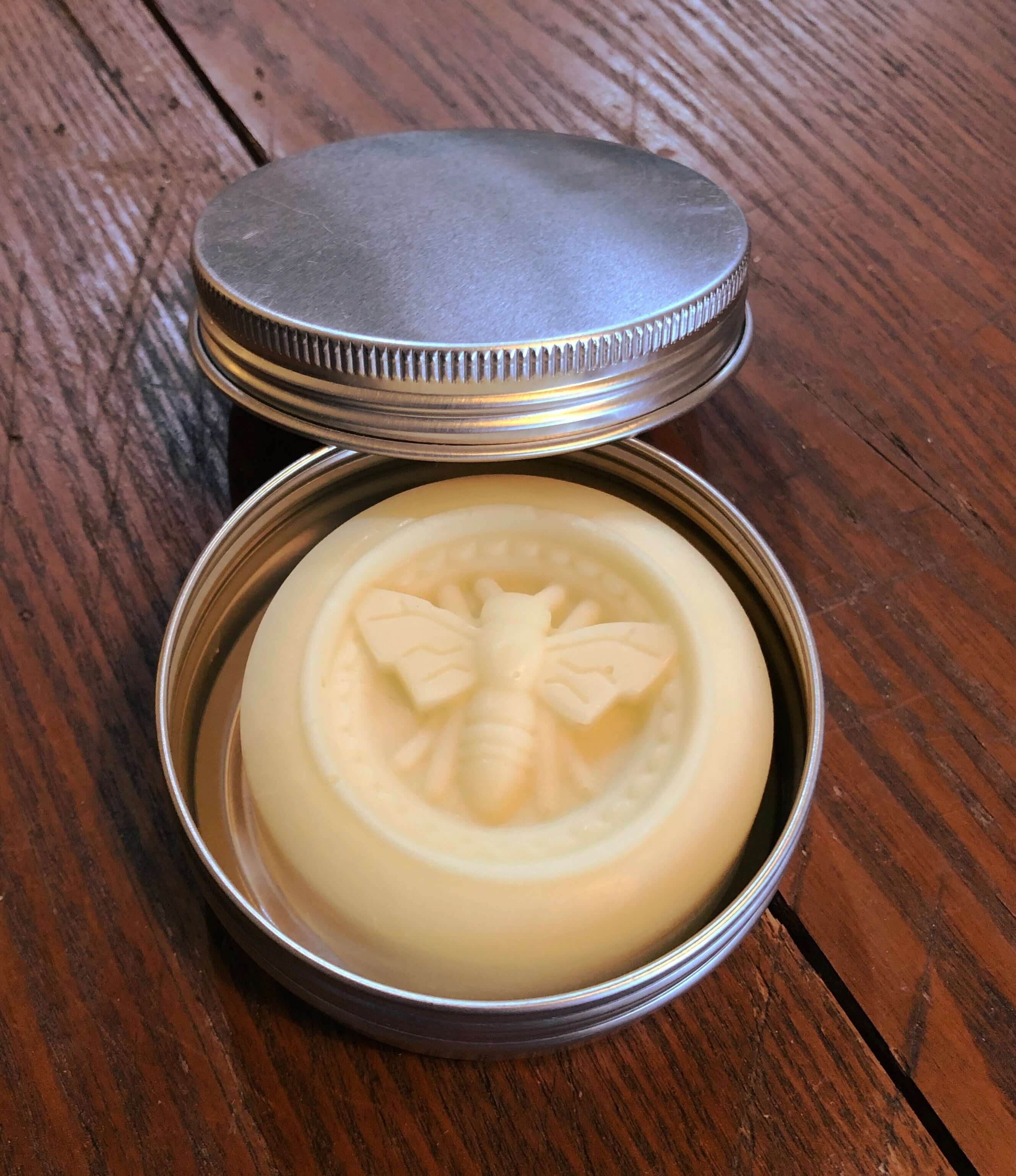 The Cure for Dry Cracked Hands - moisturizing balm in a metal tin with a bee design. Perfect for winter skin care.