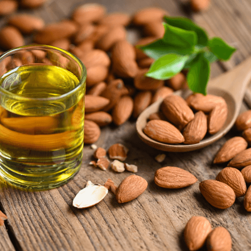 Sweet Almond Oil Benefits: A Natural Boost for Your Skincare Routine with almonds and oil on a wooden surface.