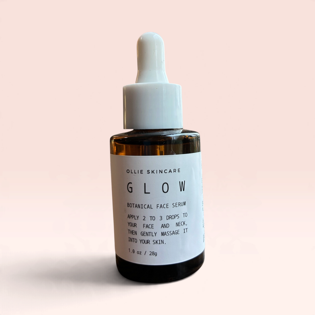 OLLIE SKINCARE Skin Glow facial serum in a 1 oz amber glass dropper bottle against a soft pink background.