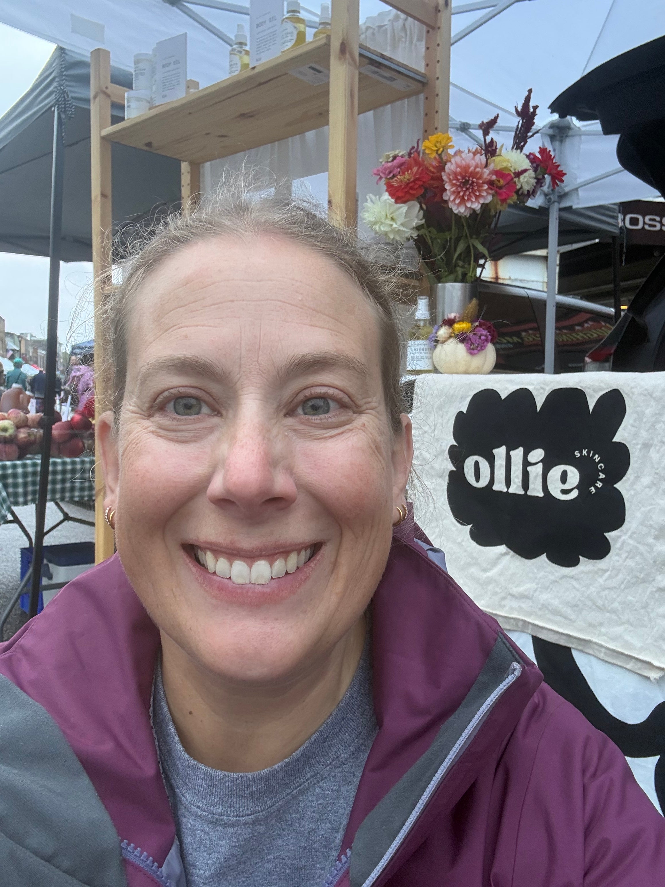 Person with a blurred face in front of a 'Ollie' store sign.