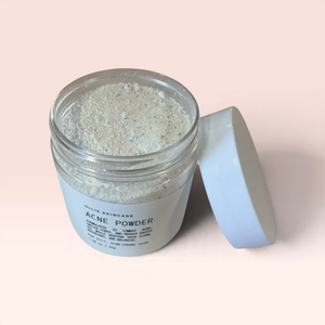 Cleansing grains in a transparent jar with a white lid, ideal for acne treatment.