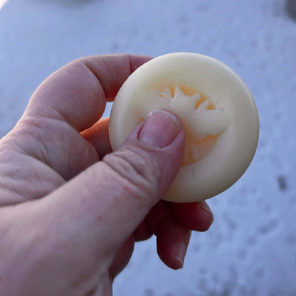 Hand holding a Solid Lotion Bar, showcasing its smooth texture and natural ingredients for soothing dry skin.