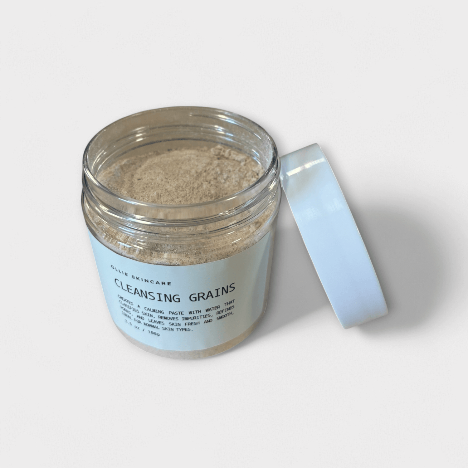 Cleansing grains in a clear jar with a white lid, ideal for skincare routines.