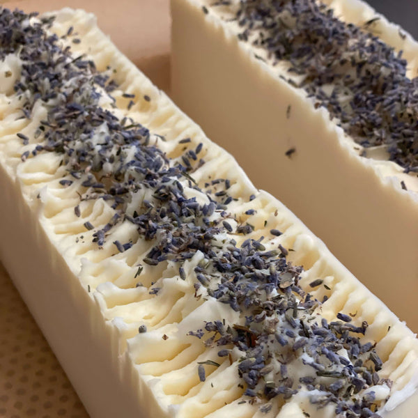 Lavender Goat Milk Soap with a creamy texture and lavender sprigs on top, perfect for gentle cleansing.