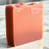 Handmade clay soap bar in soft pink hue, showcasing artisanal quality and nourishing ingredients for facial cleansing.