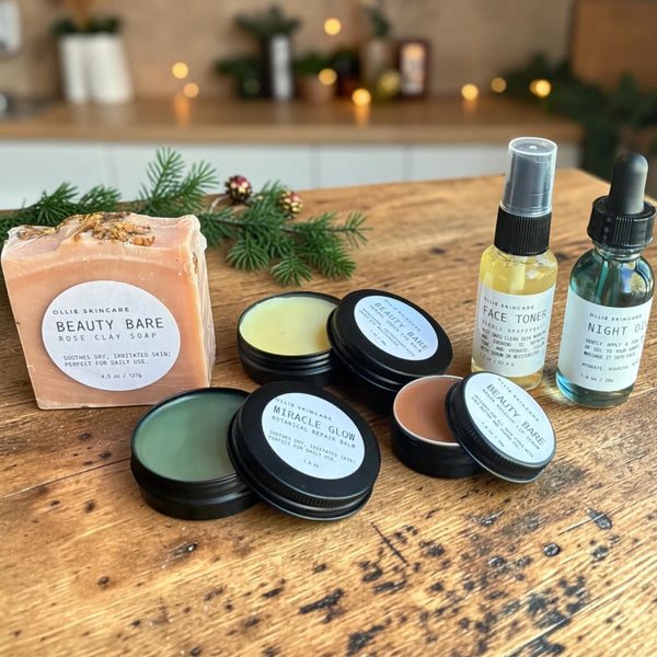Open tins of Miracle Glow Balm, under eye balm and lip serum next to rose clay soap, face toner mist and night oil.