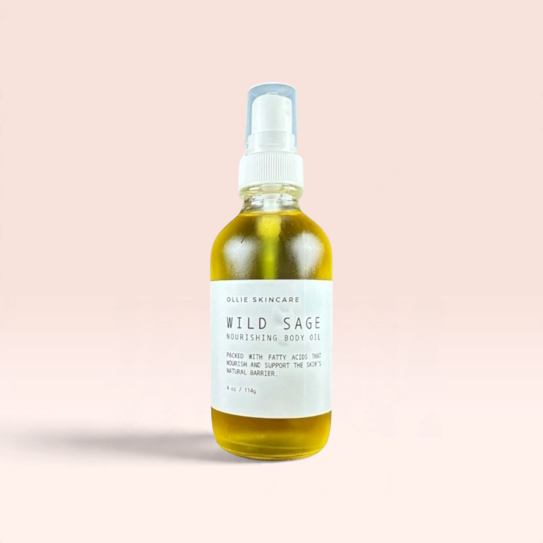 OLLIE SKINCARE Wild Sage nourishing body oil in a clear glass spray bottle against a soft pink background.