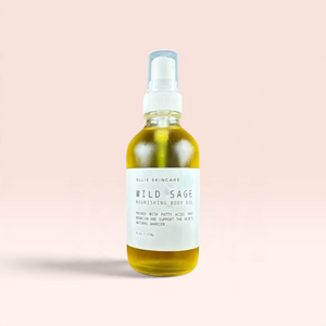 OLLIE SKINCARE Wild Sage nourishing body oil in a clear glass spray bottle against a soft pink background.