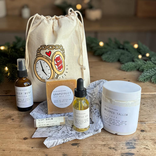 Winter Skin Rescue gift set arranged on gift tissue beside its cotton drawstring bag.