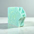 Misty Morning Goat Milk Soap bar with a unique green and blue marbled design on a white countertop.