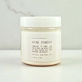 Cleansing grains in a jar labeled Acne Powder, designed for oily and acne-prone skin, promoting clean and refreshed skin.