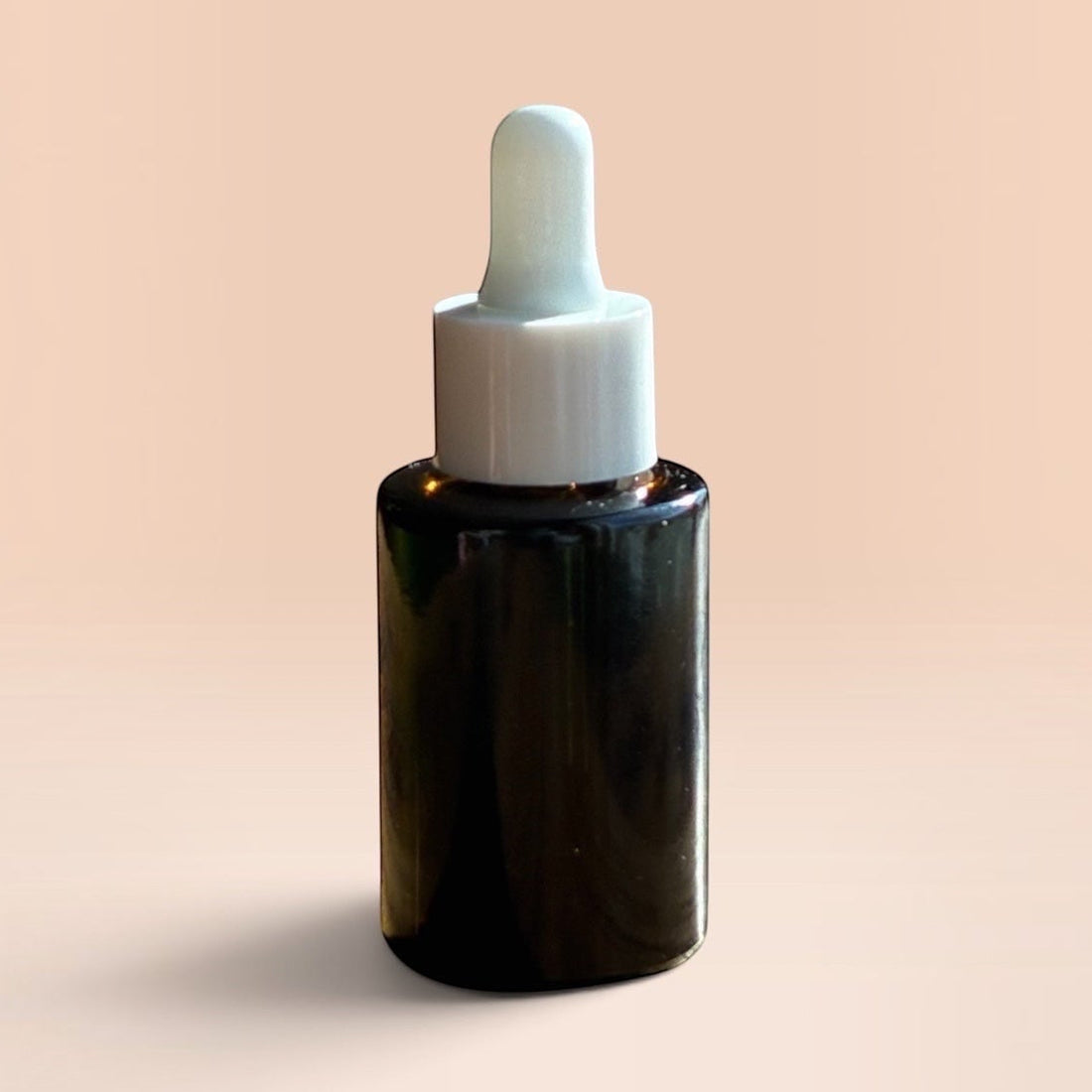 OLLIE SKINCARE Bakuchiol Facial Oil in a dark glass dropper bottle against a soft peach background.