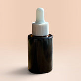 OLLIE SKINCARE Bakuchiol Facial Oil in a dark glass dropper bottle against a soft peach background.