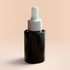 OLLIE SKINCARE Bakuchiol Facial Oil in a dark glass dropper bottle against a soft peach background.