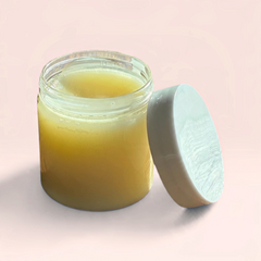 OLLIE SKINCARE nourishing makeup removing balm in a clear glass jar with a white lid against a soft pink background