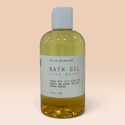 Ollie Skincare bath oil in a clear bottle with a white cap, formulated for deep skin hydration.