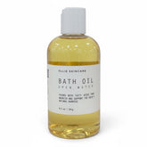 OLLIE SKINCARE Open Water bath oil in a clear 8.5 oz bottle with a white cap for deep skin hydration.