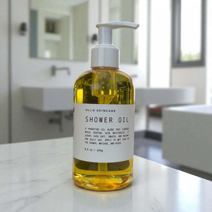 Ollie Skincare Shower Oil bottle displayed in a bright bathroom setting, promoting moisture and luxurious skin care.