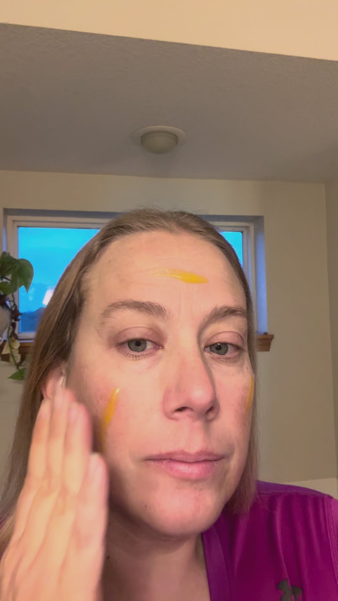 Woman applying Vitamin C Serum to her face for radiant, glowing skin and hydration.