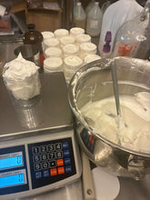 Whipped Tallow in mixing bowl alongside filled jars ready for skincare application, showcasing luxury skincare making process.